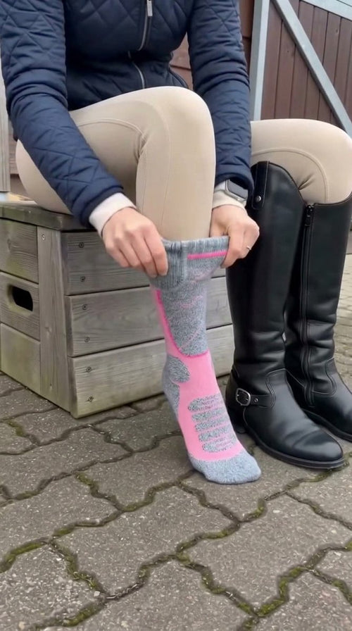 Rider wearing heated socks next to her tall boots