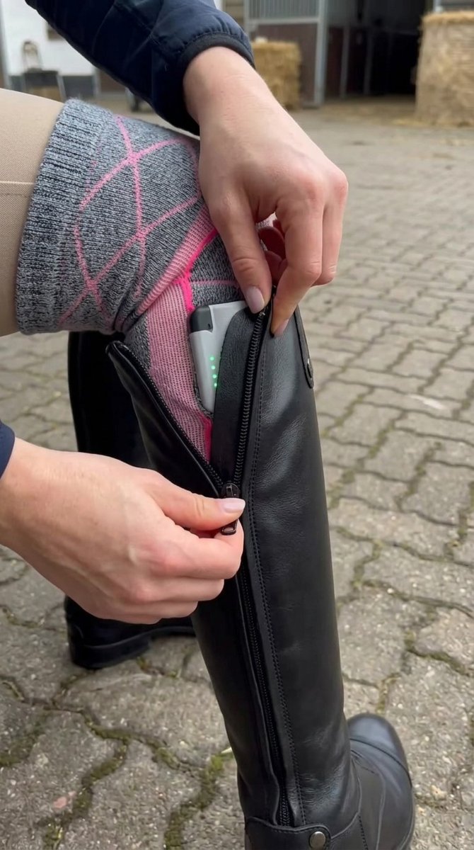 Heated sock slides into a tall riding boot